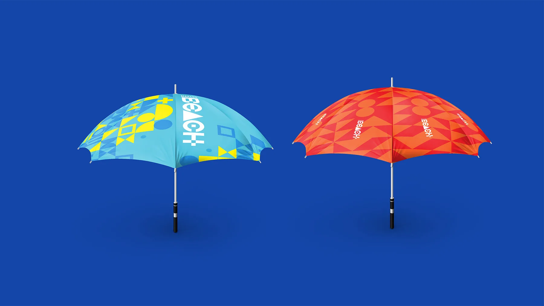 Blue and red Makers Beach branded beach umbrellas, open and facing each other