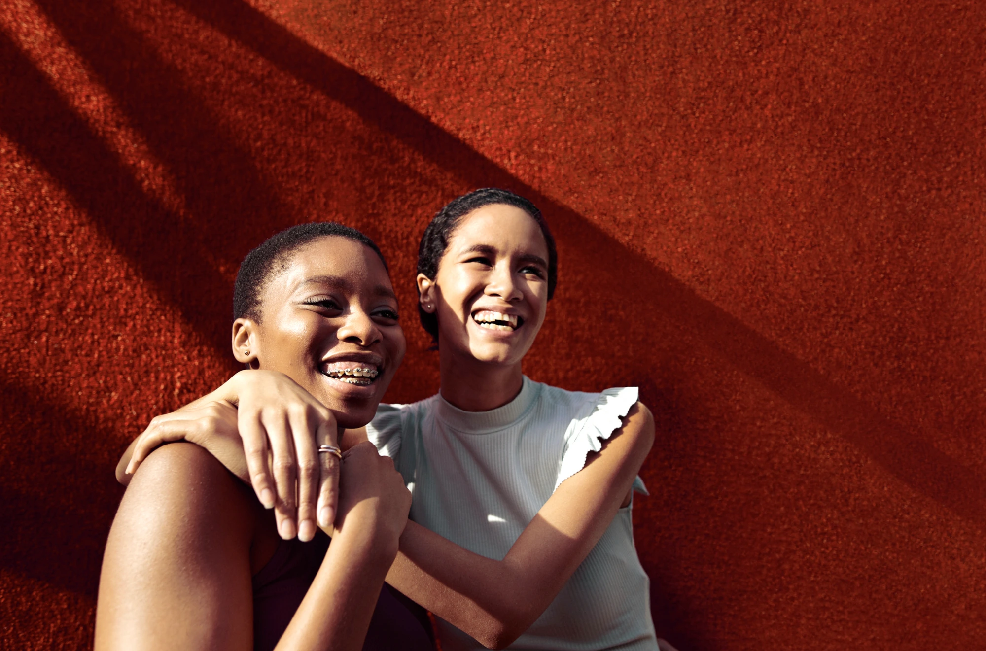 Warm, close portrait photography of two women laughing, part of the Walmart Health photography direction
