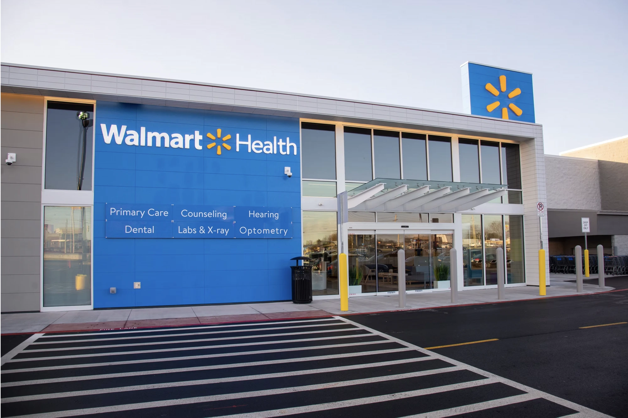 Walmart Health storefront with signage system for six services: Primary Care, Counseling, Hearing, Dental, Labs & X-ray, Optometry